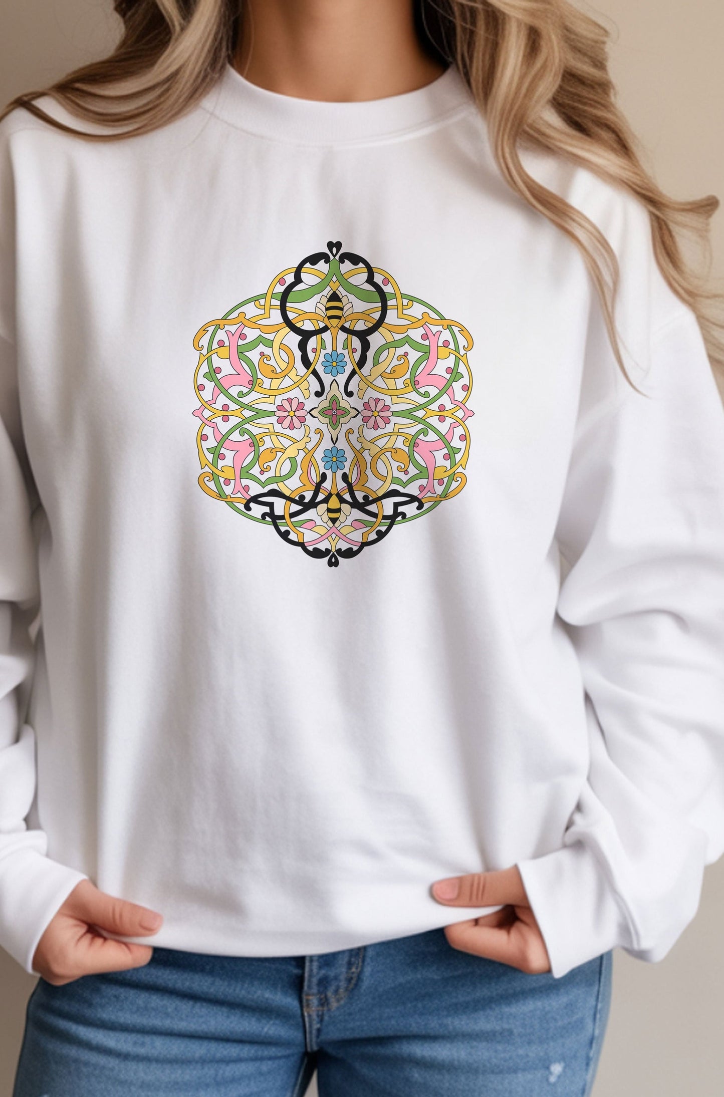 White sweatshirt with a colorful geometric design worn by a person.