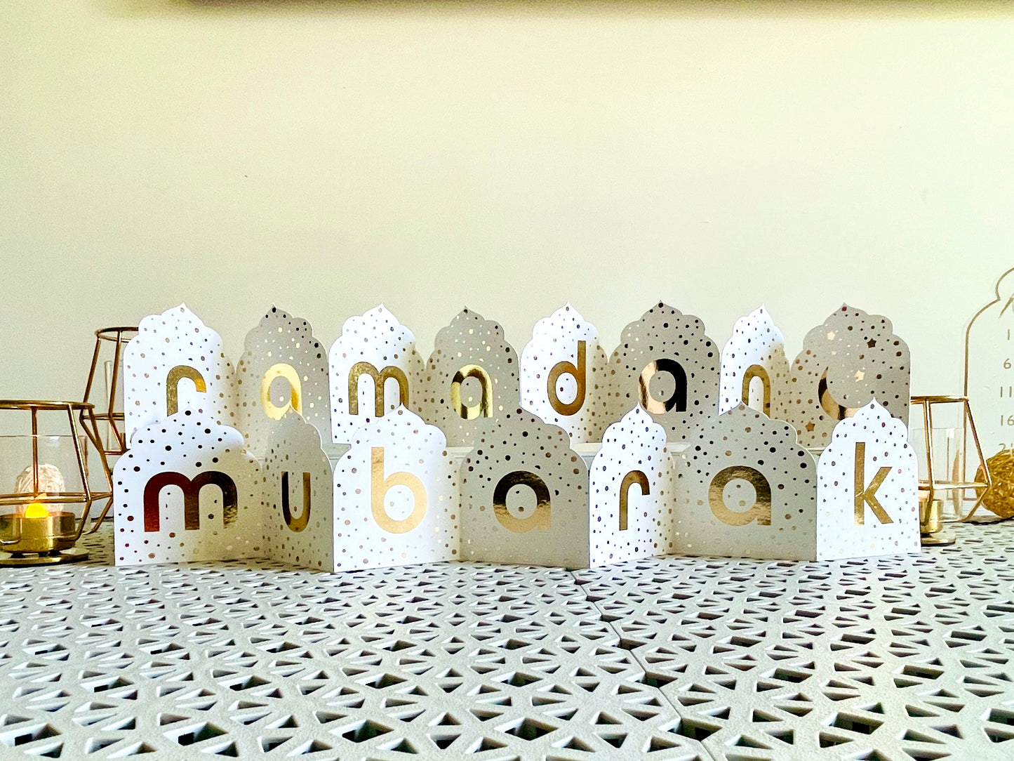 Decorative lanterns with 'ramadan mubarak' text on a textured surface.
